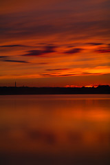 Fototapeta premium Orange and red sunset at coast of the lake
