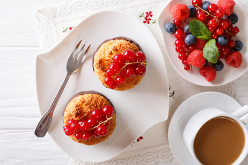 Coconut muffins with currants and coffee with milk close-up on the table. Horizontal top view