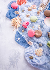 Assorted almond cookies macaroon with sea decoration on lijght gray stone background. Party food concept. Copy space.