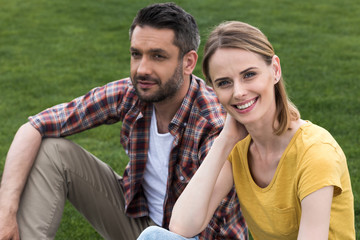 happy caucasian couple spending time together and relaxing on grass