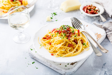 Italian pasta spaghetti Carbonara with fried bacon, parmesan cheese and parsley on white plate. Restaurant food concept.