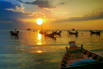 Golden Sunset and longtail boats on tropical beach