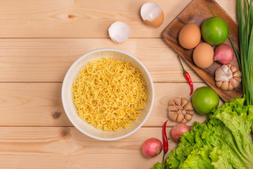Instant noodles in bowl on wood background