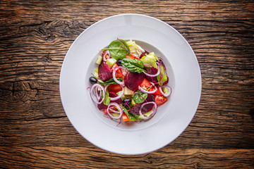 Vegetable salad. Plate of salad with vegetables  on rustic oak table. Assortment of ingredients of vegetable salad.