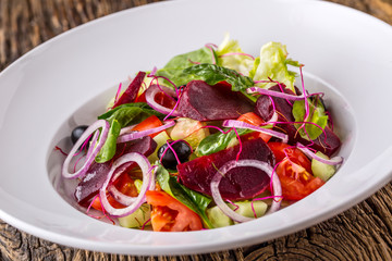 Vegetable salad. Plate of salad with vegetables  on rustic oak table. Assortment of ingredients of vegetable salad.