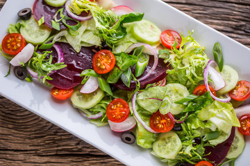Vegetable salad. Plate of salad with vegetables  on rustic oak table. Assortment of ingredients of vegetable salad.