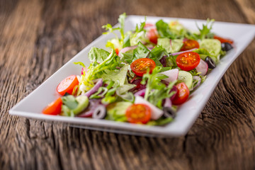 Vegetable salad. Plate of salad with vegetables  on rustic oak table. Assortment of ingredients of vegetable salad.
