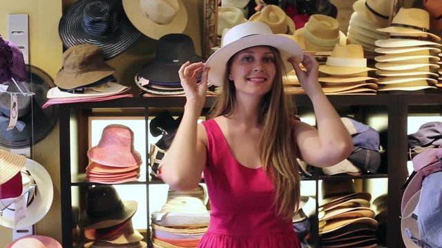 adult smiling woman try on boater hat  in shopping mall