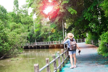 Hipster asian girl with camera breathing and looking at tropical walkway  and canal, Tourist Traveler in Asia location