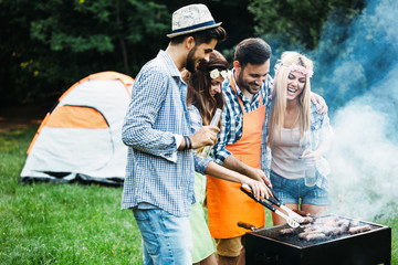 Friends spending time in nature and having barbecue