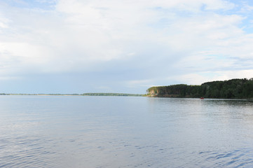 Water landscape on a summer clear day. Blue sky, clouds. Islands far away