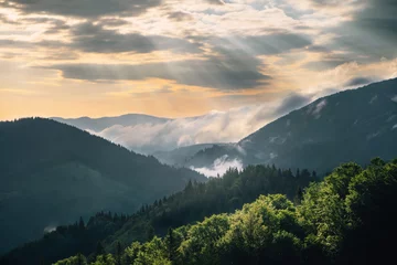 Photo sur Plexiglas Colline Colline de montagne avec brouillard et rayon de soleil au lever du soleil