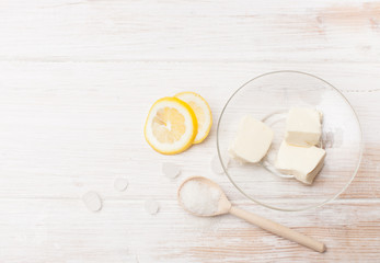 Slices of butter, lemon and sugar on a white table