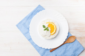 Cottage cheese with slice of orange and sour cream