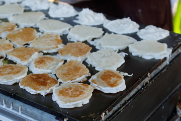 Thai street food dessert ingredients with young coconut,flour and sugar grilled on flat pan local called 