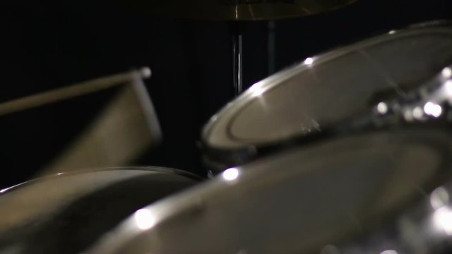 Drummer playing on drum kit.