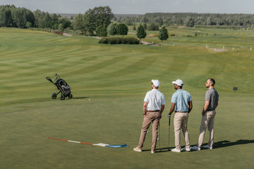 professional players looking away while standing on golf pitch