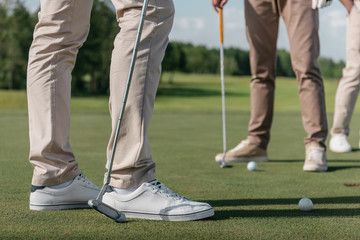 Obraz premium cropped shot of professional golf players getting ready to shot a ball