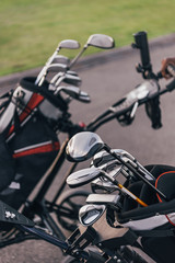 Close-up view of shiny golf clubs in golf bags outdoors
