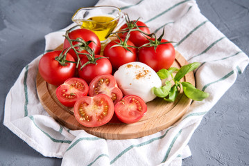Wooden board with mozzarella tomatoes basil Italian cuisine Olive oil Place for text