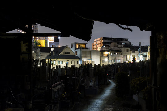 Panoramic photo of Tokyo suburb at night captured from cemetery apartment houses are illuminated 