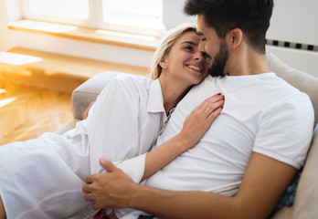 Cute couple hugging and smiling in their home