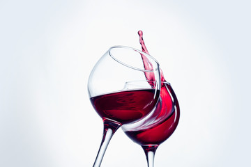 Two wine glasses in toasting gesture with big splashing.