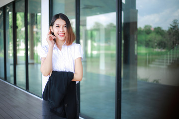 Fototapeta premium Modern business women casual outfits in the office with copy space, Business woman standing cross one's arm, Asian people young beautiful businesswoman smile. business concept