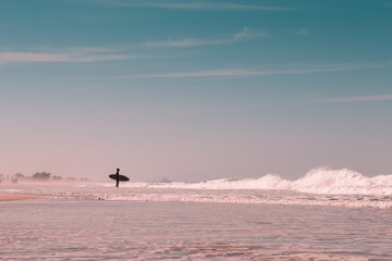 Silhouette surfer in idyllic light beach