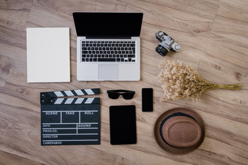 office table equipment,working table in office background such as laptop computer blank paper tablet smart phone hat old camera and slate for movie director concept,vintage tone