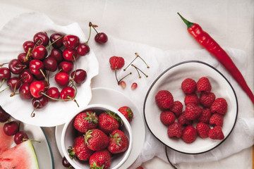 Red fruit and vegetable composition on linen fabric. Summer natural beauty concept with copy space.