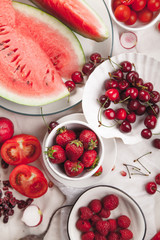 Red fruit and vegetable composition on linen fabric. Summer natural beauty concept with copy space. Vertical composition