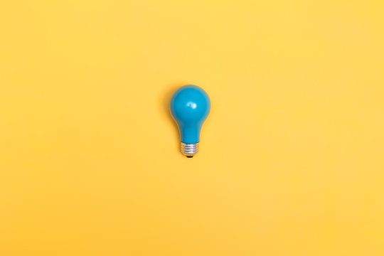 Blue painted light bulb on a vibrant background