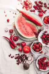 Red fruit and vegetable composition on linen fabric. Summer natural beauty concept with copy space. Vertical composition