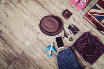 travel accessories top view,travel outfit casual and equipment such as hat tablet suitcase shirt jeans eyeglasses,vacation time concept,vintage tone
