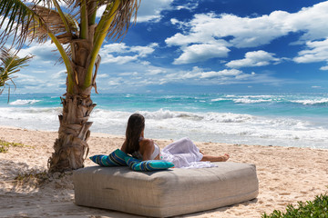 Frau entspannt auf einem luxus Sonnenbett am Strand der Karibik