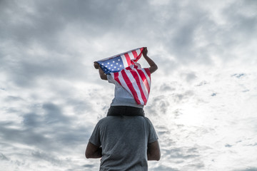 Patriotic holiday in USA,Father and son with American flag outdoors.USA celebrate 4th of July.Happy family independence day
