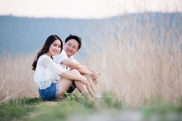 Beautiful young dating couple in city taking photos on park during sunset time