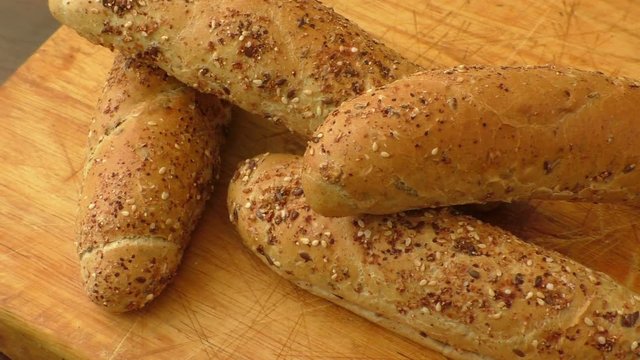 Freshly baked delicious crusty rolls on a rustic wooden worktop 
