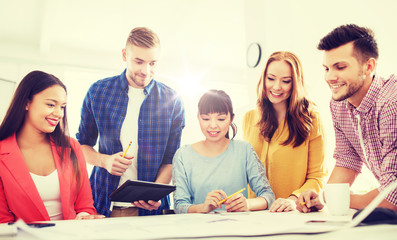 creative team with blueprint working at office