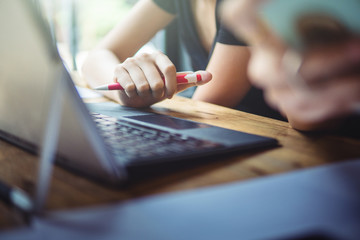 woman working on laptop,business office desk,using laptop computer technology on table for searching and planing successful concept,vintage tone and day light flare.