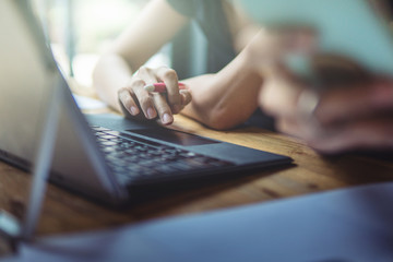 woman working on laptop,business office desk,using laptop computer technology on table for searching and planing successful concept,vintage tone and day light flare.