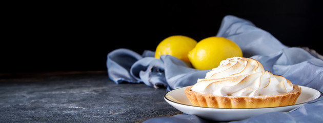 French dessert. Tartlet with lemon. Dark background.