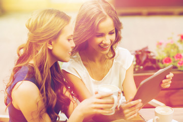 young women with tablet pc and coffee at cafe