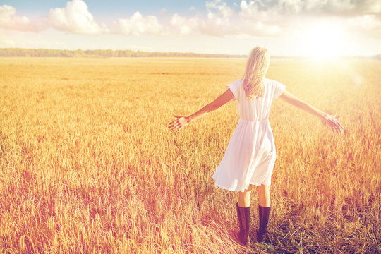 happy young woman in white dress on cereal field