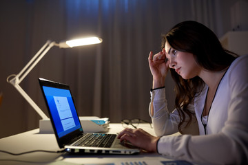 businesswoman with laptop at night office