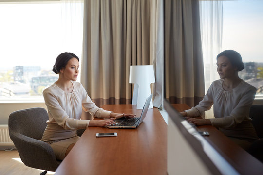 businesswoman typing on laptop at hotel room