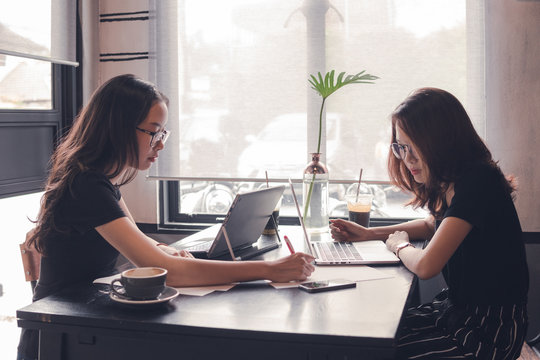 woman working with laptop,teamwork business brainstorm,business cooperation working on desk,tutor revise and learning education,enjoy working and brainstorming on cafe,vintage tone and selective focus