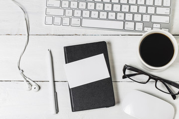 Blank paperwork template for designers. Responsive design mockup on vintage wooden background. Paper, letterhead, coffee cup, smartphone, pencil and headphones on wooden table background. Top view.