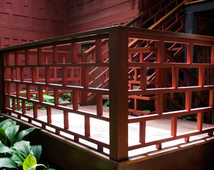 Fototapeta na wymiar Red wooden handrail of Jim Thompson House in Bangkok, Thailand